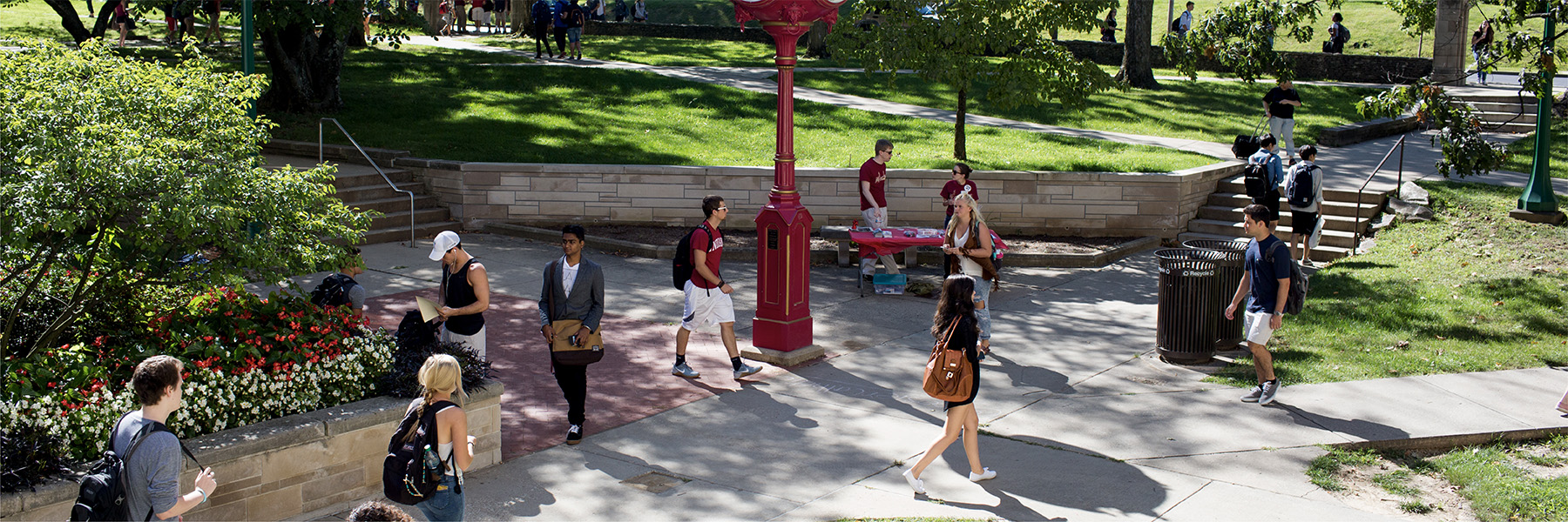 Students walking near a red outdoor clock on the Indiana University Bloomington campus