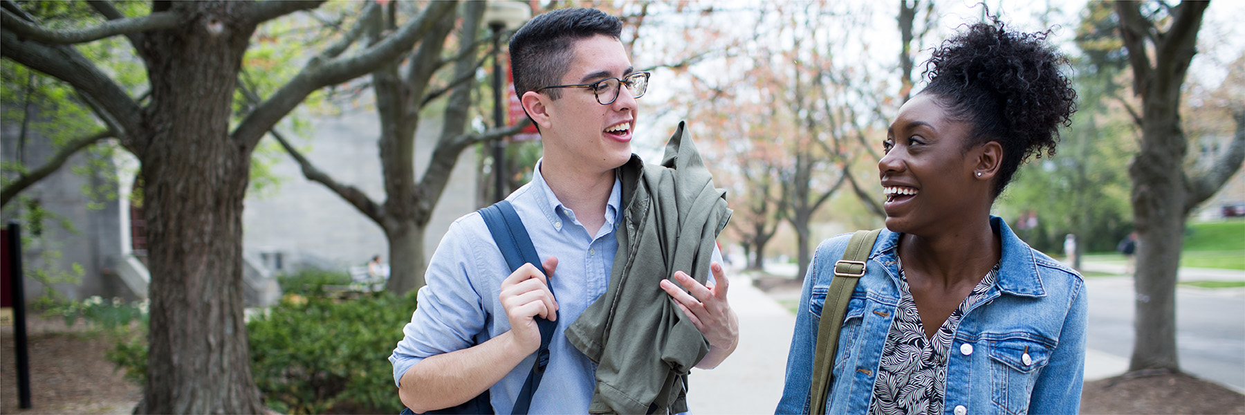 Two students talking as they walk through campus